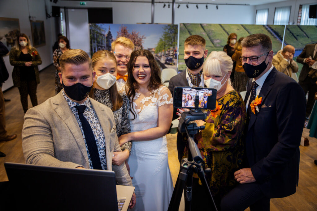 Bruidspaar en familie dragen een mondmasker tijdens et bruiloft